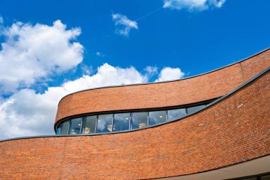 Gökyüzü arkaplanlı kırmızı tuğla bina.