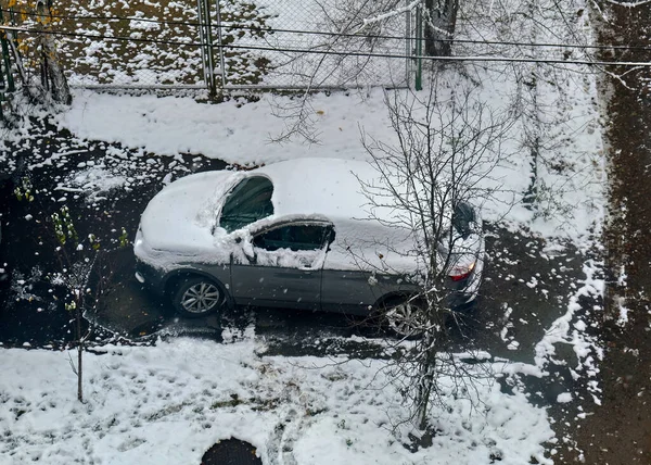 Araba çitin yakınındaki karda park halinde ve çitlerle çevrili..