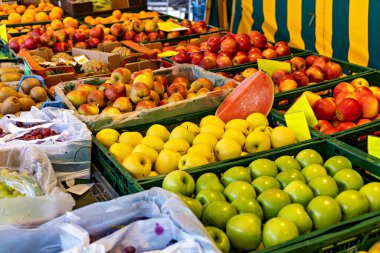 Elmalar, portakallar, limonlar ve elmalarla meyve standı.