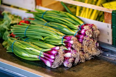 Bir avuç soğan tezgahın üzerinde diğer sebzelerin yanında oturuyor..