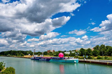 Almanya, Ludinghauchen, 2022 civarı. Su kanalındaki iskelede büyük pembe bir balonla güzel dekore edilmiş bir mavna. Bilim Yılı 2022.