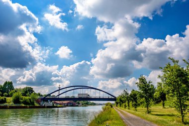Nehrin üzerindeki köprüde gökyüzünde büyük bulutlar var..