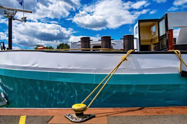 Büyük beyaz ve mavi gemi güneşli bir günde açık mavi gökyüzüyle rıhtıma yanaştı..