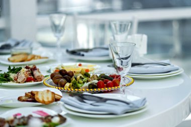 Tabaklar dolusu yiyecekle kaplı bir masa. Bardaklar dolusu su ve tabaklar dolusu yiyecek..