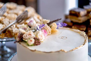 Üzerinde çiçekler ve bıçak olan düğün pastasını kapat..