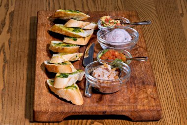 Dilimlenmiş ekmek sosu ve baharatlı tahta kesme tahtası.