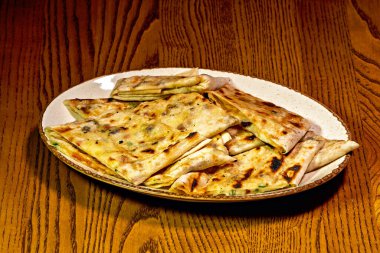 Tahta bir masada bir tabak yemek.