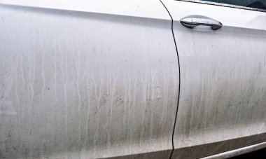 Su damlacıkları ve çizgileriyle yakın plan beyaz araba kapısı yağmuru ya da yağmuru işaret ediyor.