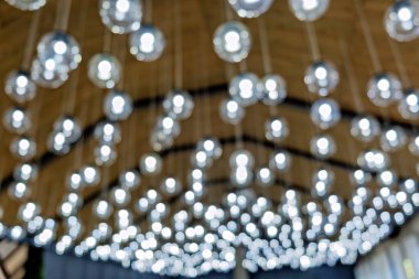 Kablolardan sarkan sayısız küçük ışıklı bir tavan boşluğu parlak bir ışıltıyla dolduran bir şablon oluşturuyor.