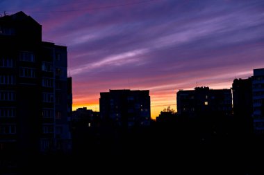 Gökyüzündeki sıcak renkler göz önüne alındığında gün doğumu ya da günbatımı gibi görünen bir şehrin güzel bir görüntüsü.