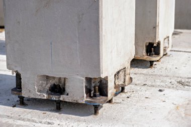 Görünür cıvataları ve üzerinde mavi bir işaret olan beton bir yapı.