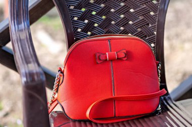 Bu, önünde fiyonk olan kırmızı bir el çantası.