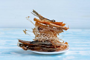 Bu resim bir tabak dolusu kızarmış balık ya da deniz ürünleri gösteriyor.