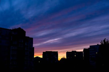 Bu, gün doğumu ya da gün batımı gibi görünen bir şehrin gökyüzünün güzel bir görüntüsü.