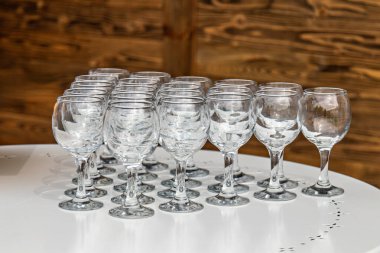 Bu resim beyaz bir yüzeyde düzgünce dizilmiş bir şarap kadehi koleksiyonunu gösteriyor.