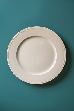 Mavi arkaplandaki boş seramik plakanın üst görünümü