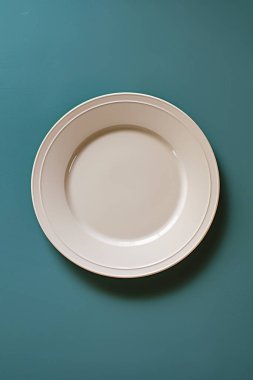 Mavi arkaplandaki boş seramik plakanın üst görünümü