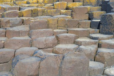 Dalgalar, Kuzey İrlanda 'nın kayalık sahillerinde, Giants Geçidi' nde, büyüleyici, altıgen kaya oluşumuna çarpıyor..