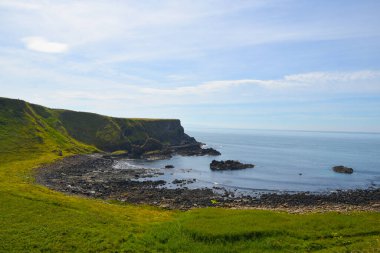 Dalgalar, Kuzey İrlanda 'nın kayalık sahillerinde, Giants Geçidi' nde, büyüleyici, altıgen kaya oluşumuna çarpıyor..