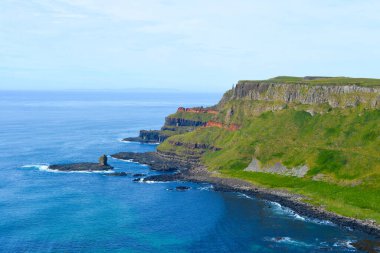 Dalgalar, Kuzey İrlanda 'nın kayalık sahillerinde, Giants Geçidi' nde, büyüleyici, altıgen kaya oluşumuna çarpıyor..