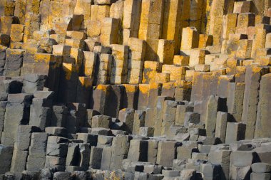 Dalgalar, Kuzey İrlanda 'nın kayalık sahillerinde, Giants Geçidi' nde, büyüleyici, altıgen kaya oluşumuna çarpıyor..