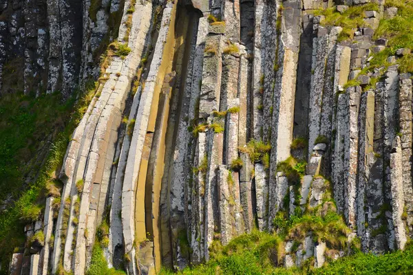 Dalgalar, Kuzey İrlanda 'nın kayalık sahillerinde, Giants Geçidi' nde, büyüleyici, altıgen kaya oluşumuna çarpıyor..