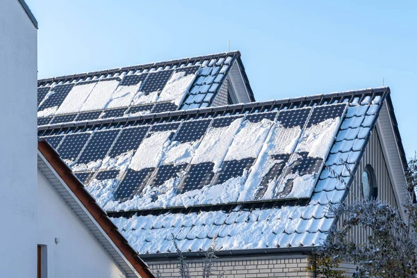 roof of a building with photovoltaic power plant covered with snow