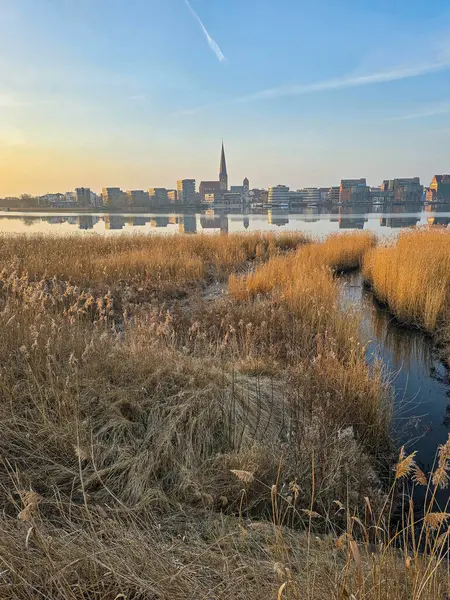 Rostock şehrinin panorama 'sı, sabahın erken saatlerinde şafak vakti, nehir savaşı manzarası