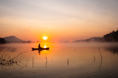 Women on kayak rows in the reservoir during the sunrise, Harirak forest park Huai Nam Man reservoir Loei Thailand 21 Jan 2023