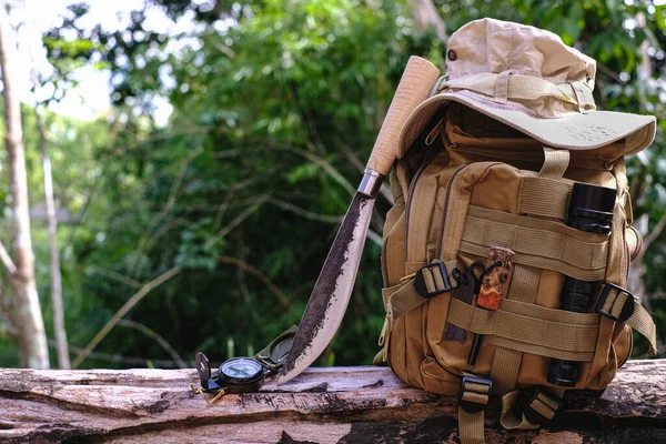 Knife backpack with equipment for survival in the forest on an old timber wooden