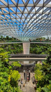 Singapur, 7 Nisan 2025: Parallax view of indoor Singapur rain vortex şelale in rain forest Jewel Changi Airport Singapur