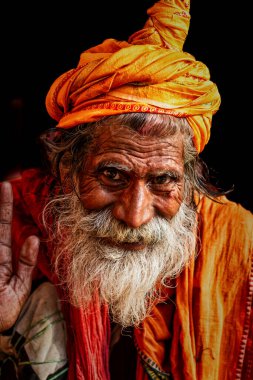 Varanasi, Hindistan - 18 Mart 2014: Hinduizm ve Jainizm 'de eski saddhu (dini münzevi ve kutsal kişi) gözlerinde yoğun bir bakışla yukarı bakar.