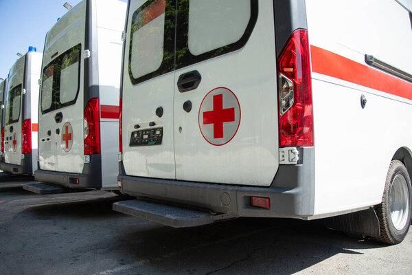  Ряд машин спасателей. Вид сбоку на машины скорой помощи, стоящие на парковке 