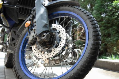 Ön tekerleği ve fren diski olan bir motosiklet parçası. Yakın plan.