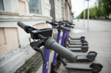 Şehre park etmiş bir sürü elektrikli scooter. Elektrikli şehir ulaşımı .   