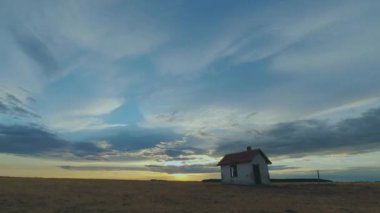 Gün batımında kırsal kesimdeki bir evin üzerindeki kara bulutların zamanlanmış görüntüleri, Hortobagy Ulusal Parkı, Macaristan