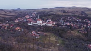 Romanya 'nın Harghita ilçesindeki Drjiu (Szkelyderzs) köyünde yüksek çan kulesi bulunan ünlü güçlendirilmiş kilisenin manzarası, Szkely Land, hava manzarası