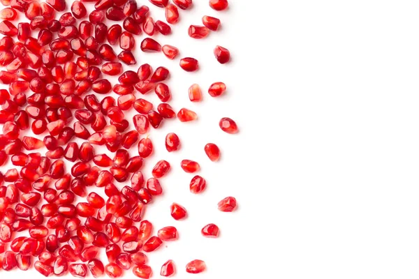 Red grains of a ripe pomegranate are neatly laid out on a white background top view with place for text. Pomegranate grains on isolated flat lay. Background of pomegranate seeds.