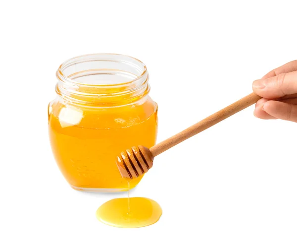 蜂蜜从白色背景的木制酒壶和装有有机蜂蜜的透明玻璃瓶中滴下 将蜂蜜勺子和新鲜蜂蜜放在碗中隔离特写 — 图库照片