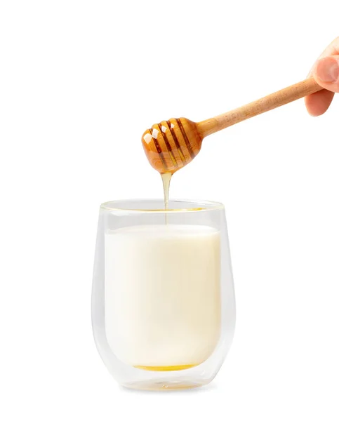 蜂蜜从一个木制的传送器流入白色背景的一杯牛奶中 蜂蜜从蜂蜜汤里滴到牛奶里 隔离时牛奶和蜂蜜的概念性照片 — 图库照片