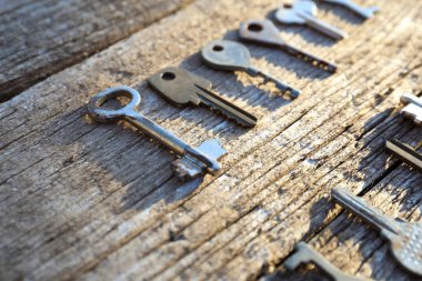 Ahşap arka plan manzarasında farklı eski anahtarlar. Antika bir surfac üzerinde farklı şekillerde eski anahtarlar
