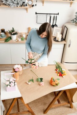 Girl makes flowers from the soap. Hobby, creative process. DIY gifts. Women's hands and flowers. Handmade soap. Mother's Day, Women's Day. Natural organic products. Flowers on a white table.