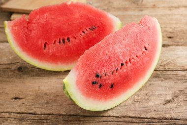 Eski ahşap bir arka planda olgun bir karpuz dilimi. Dilimlenmiş meyve..