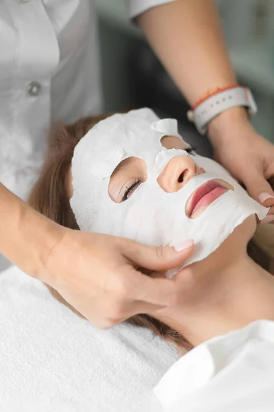 Face and body treatments. The concept of maintaining health, youth and beauty. Face masks, modern cosmetology, beautician tools, hands with gloves. Beauty techniques.