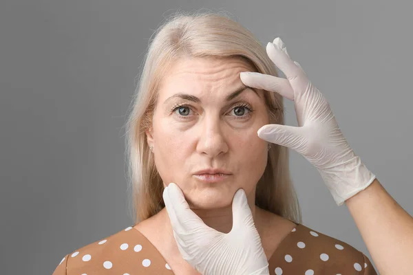 stock image Young caucasian woman getting botox cosmetic injection in a forehead. Beautiful woman gets botox injection in her face. Adult girl gets cosmetic injection of botox in a clinic. Beauty treatments