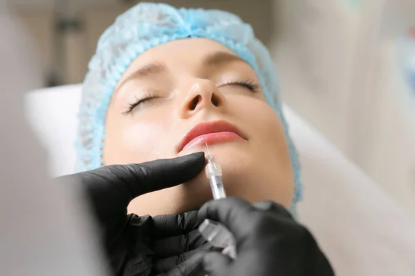 stock image  Beauty treatments by a beautician close up. The concept of improving the appearance. Lip augmentation, symmetry, plump lips. New techniques in cosmetology. Gloved hands. Syringe in hand.
