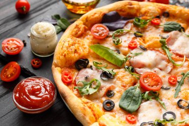 Tütsülenmiş et, zeytin, peynir ve otlar, soslar, baharatlı zeytin yağı ve siyah ahşap zemin üzerinde taze sebzeler. Geleneksel İtalyan yemekleri.