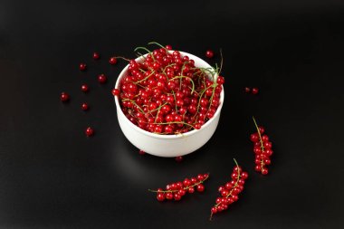 red currant branches on a dark background close-up copy space. Useful dietary product.