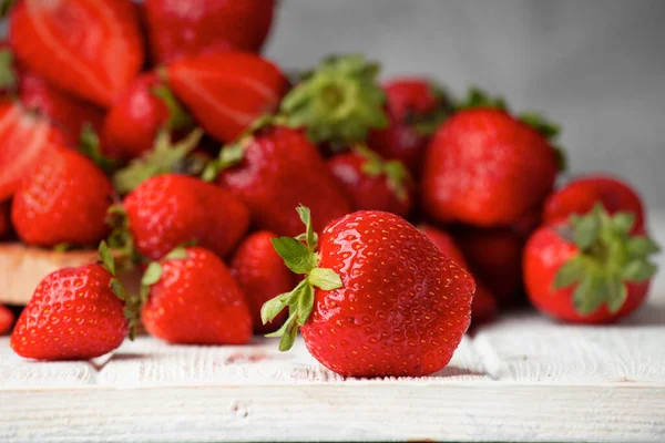 stock image A hill of red Strawberry with water drops on a light background close-up. Useful dietary product.