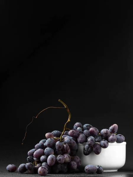 Куча Винограда Белой Тарелке Темном Фоне Ветка Черного Винограда Каплей — стоковое фото